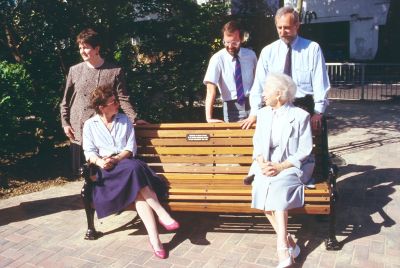 Dedication of seat at Library Green
In 1990, inspired by the Preservation Society, Enfield Council and British Telecom co-operated in an Environment Week which made a dramatic improvement to a corner of the Library Green. The prime movers, shown here, were (left to right) standing, Nicola Rossi (British Telecom), Stever Jaggard (borough engineer's department) and Nigel Tomers (borough planning department). Sitting on the seat (later stolen) which was donated by British Telecom, are Prue Lambert and Beryl Dorrington. - [i]Fighting for the future[/i], p.200.
Keywords: 1990s;seats;events