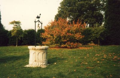 Carved well-head (?) in a park
Surmounted by a metal frame with a stylised cockerel. 
Keywords: wells;parks