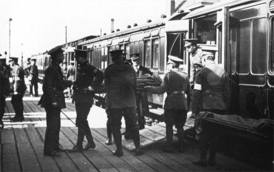 Wounded soldiers as stretcher cases being unloaded from train
The first of 139 wounded men arrived at Lower Edmonton low level station on Friday evening, 14th May 1915. A large crown waited there, flowering plants were brought from Barrowfield nurseries, someone produced a Union Jack and "Welcome to our heros" was chalked up on the wall. - [i]History of Enfield[/i], vol.3, p.25.
Photograph by Cyril Marsh Neaves (1877-1934), official photographer of the Middlesex Voluntary Aid Detachment (VAD), 1914-1918.
Keywords: soldiers;World War I;postcards;railway stations;rail transport