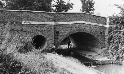 Maiden's Bridge
Built in 1761, The upper parts were rebuilt in 1968 after extensive damage by a lorry. A bridge was recorded here in medieval times, with an adjacent water mill. - [i]Treasures of Enfield[/i], p58.

This picture was in Enfield Camera Club 1981 exhibition.
Keywords: bridges;streams;graffiti