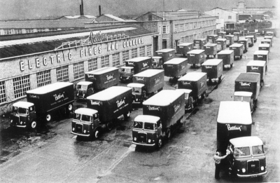 Belling factory: delivery lorries
Photograph has caption: "First off in the morning - some of the 86 vehicles in the transport fleet, parked in front of the main Administration Block. Deliveries are made to all the major towns twice a week, and in many cases daily." 
Keywords: factories;lorries;road transport;industry