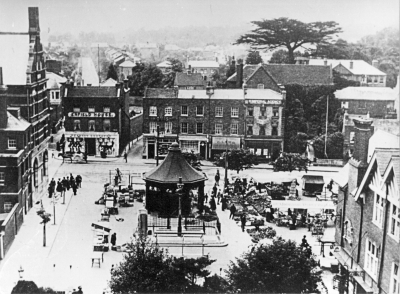 Market place viewed from the church tower, about 1905
The "Palace" is behind the shops on the far side of Church Street. Dr Uvedale's great cedar still dominates the skyline. The shop on the left, with the sign "Enfield House" has the lower sign "Pearson Brothers". - [i]History of Enfield[/i], vol.2, page 41.
Keywords: 1900s;market places;shops;trees;Palace;snow