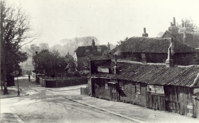 Chase Side from Trinity Street
Before 1990. Chase Side crosses from left to right. Round the right-hand corner in Chase Side stood the bow-windowed beer house known as "The Vine". Pennyfathers Fields through the gate on the left. Ivy Cottage, centre back. 
Keywords: 1880s;roads and streets