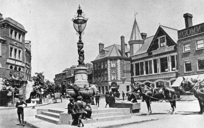 Fountain, Enfield Town
An early photograph, looking towards Silver Street, before the trams came to Enfield Town. The lamp on the fountain has a vertical gas burner, later replaced in 1901-1908 by a three-arm inverted burner lamp.
Keywords: 1890s;fountains;street furniture;lamps;horses;horse-drawn vehicles