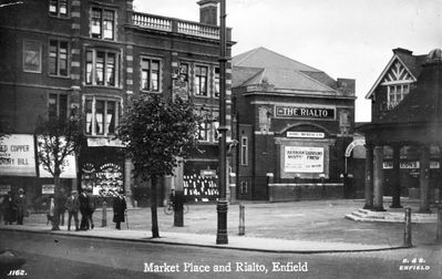 Market place and the Rialto, 1923.
The cinema shows advertisements for "Arabian nights" and "Garrisons finish" a film made in 1923 subtitled "Winning life's handicap", a race track drama in 3 reels from the popular novel by W.B.M Ferguson.
The Rialto was built in 1920. The cost of the building was so high that the owners were declared bankrupt in 1925. The building was later used as a bingo hall, and was demolished in 2011. In the Market Place next to the Rialto was the shop of Leapman, a clothier, next door was Henry Smith, a confectioner who sold teas and ices, the the Gas Company's showrooms. - [i]History of Enfield[/i] vol.3, p230.
Keywords: cinemas;market places;postcards;demolished buildings