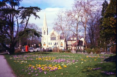 Library Green with crocuses in flower and Trinity Church, 1977
In 1963 Enfield Preservation Society volunteers planted 1000 crocus bulbs on the Library Green.
The small single-storey building to the right of centre was a public toilet, now regrettably closed to the public and used only by bus staff.
Keywords: 1970s;churches;flowers;flora and fauna;greens;parks;toilets;telephone kiosks