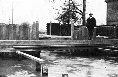 New River at Hedge Lane, 1920
This was a rebuild of the bridge across the New River at Hedge Lane, Palmers Green. The man shown is David Fisher's great-grandfather, James Renshaw Day who was a foreman in charge of works on the New River for 49 years. - [i]Information from David Fisher, 2015-12-04.[/i]

The date 12.3.20 is shown at the bottom of another copy of this image.
Keywords: rivers and streams;water supply;bridges;New River